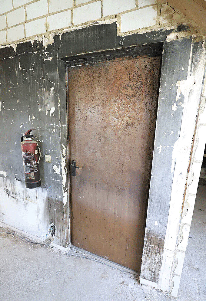 Noch immer tragen Brandschutztür und Feuerlöscher im Obergeschoss deutliche Spuren der Brandnacht
