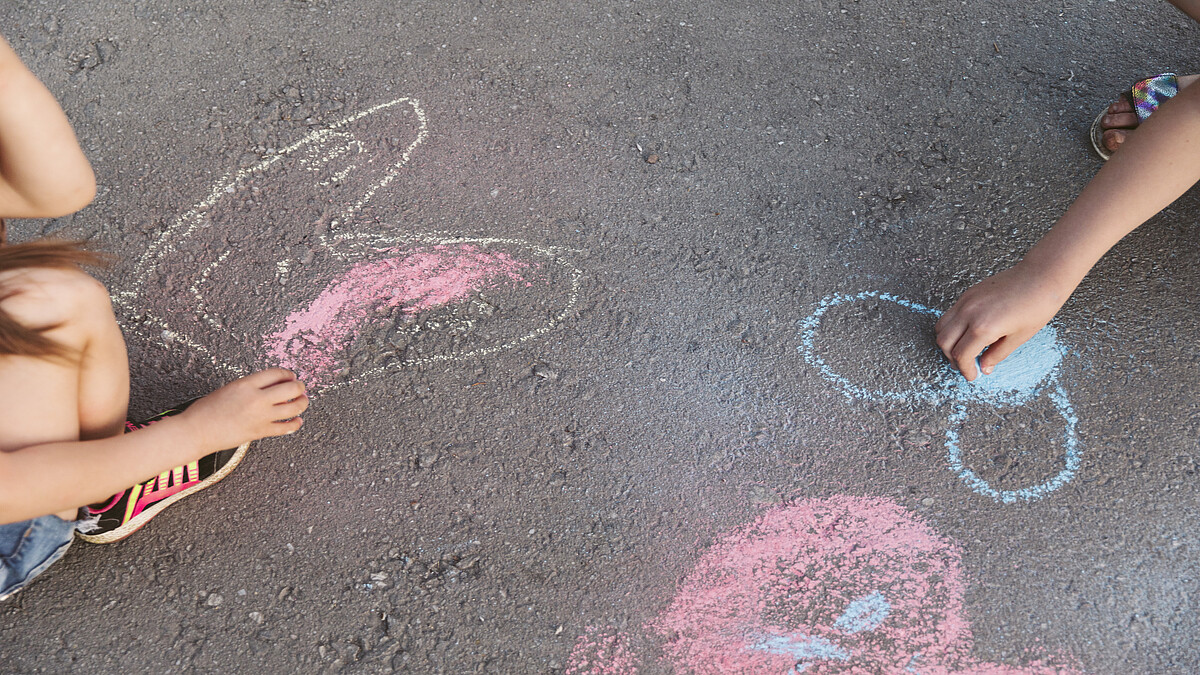 Kinder malen Kreide auf Straße. Quelle: Freepik