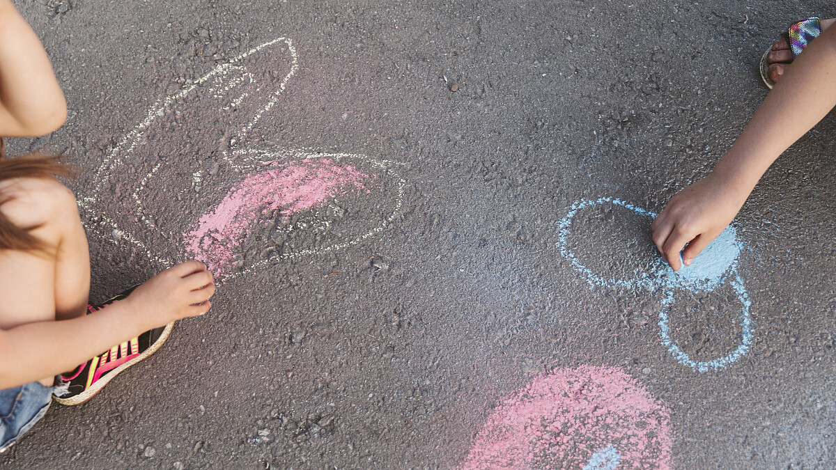 Kinder malen Kreide auf Straße. Quelle: Freepik