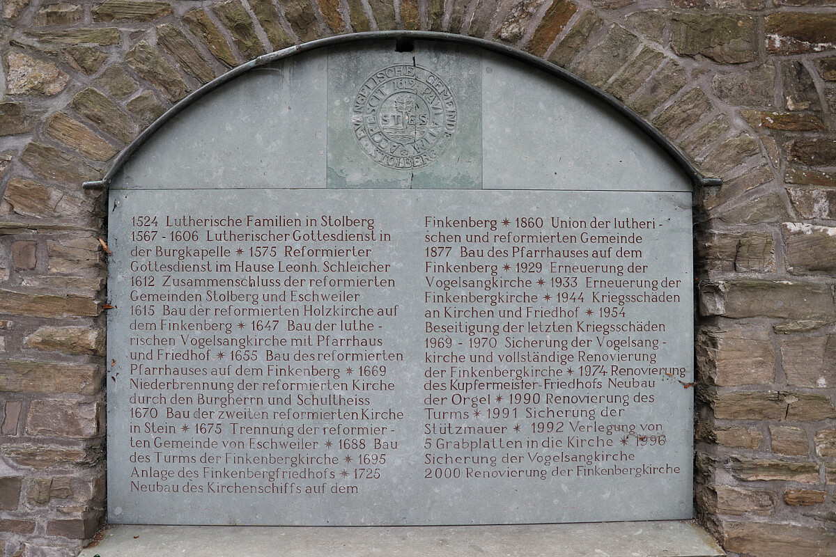 Wichtige Daten der Geschichte der Ev. Kirchengemeinde Stolberg sind neben der Finkenbergkirche an einer Steinplatt abzulesen