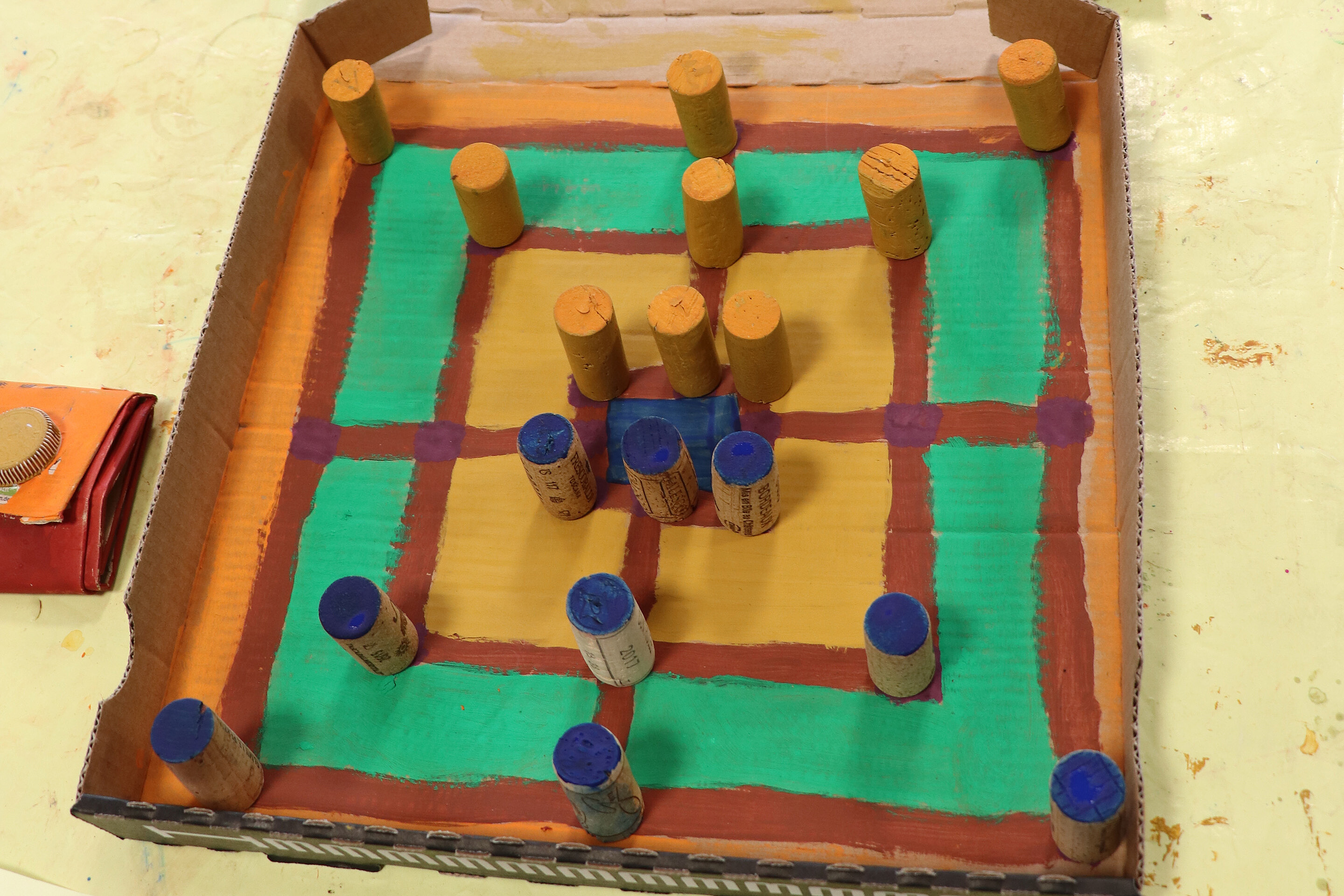 Das Mühle-Spiel stellten die Kinder aus einem Pizza-Karton, Korken und Farbe selbst her.